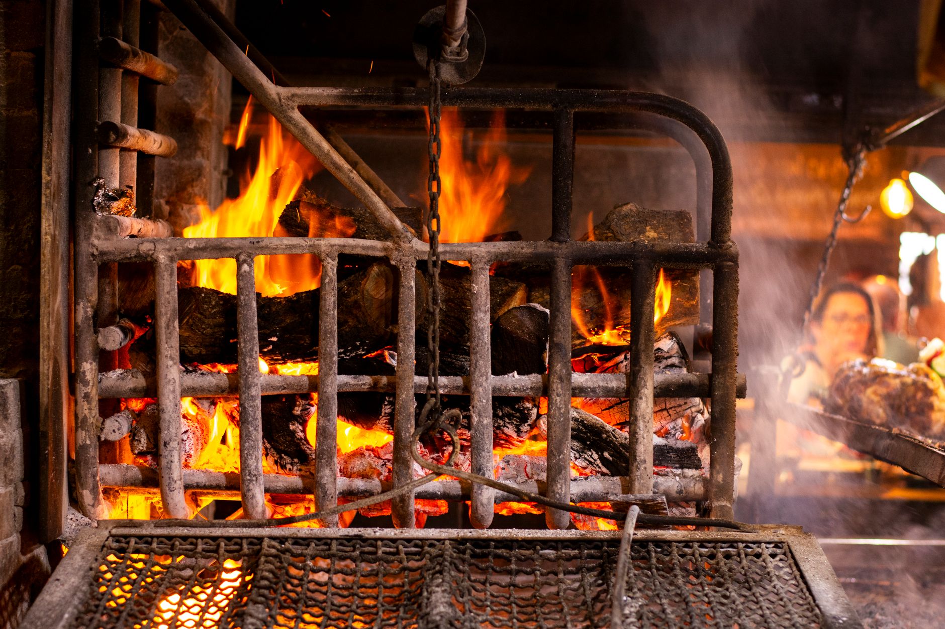 Cazuela humeante de guisado de carne sobre el comal de leña del restaurante